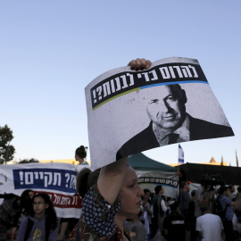 An Israeli protester holds a placard depicting Israeli Prime Minister Benjamin Netanyahu during a demonstration against a court decision to demolish housing units in the Jewish settlement of Beit El, outside the Supreme Court in Jerusalem J