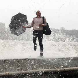 Una ola golpea a un indio durante la marea alta en el paseo marítimo de Bombay, India. El ochenta por ciento de las precipitaciones totales en la India se recogen durante el paso del monzón, de junio a septiembre. EFE/Divyakant Solanki