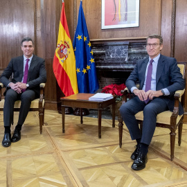 El presidente del Gobierno, Pedro Sánchez (i), y el líder del PP, Alberto Núñez Feijóo (d), posan durante una reunión, en el Congreso de los Diputados, a 22 de diciembre de 2023