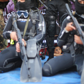 Un niño palestino observa miembros de la unidad marítima de al-Qassam participar en un desfile anti-israelí en Rafah, en el sur de la Franja de Gaza 13 de julio de 2015. REUTERS / Ibraheem Abu Mustafa