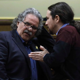 El portavoz del ERC, Joan Tardà (i), conversa con el líder de Podemos, Pablo Iglesias, durante la última sesión de control al Ejecutivo del año que celebra hoy el Congreso con la vista puesta en el Consejo de Ministros del próximo viernes e