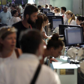 Personal de facturación de Vueling atiende a los viajeros en el Aeropuerto de El Prat, después de que la aerolínea haya cancelado esta mañana una decena de vuelos con destino u origen Barcelona y que la mayoría de rutas acumulen retrasos, a
