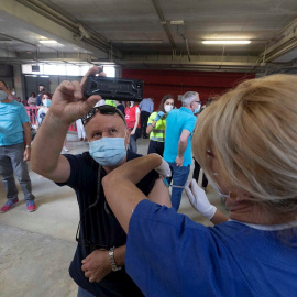 Un hombre se fotografía mientras una enfermera lo vacuna con Pfizer contra la covid-19, este viernes en el estadio Nueva Condomina de Murcia.