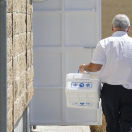 27/08/2019.- Un operario del Ayuntamiento de Sevilla llega con unas neveras para recoger muestras en la sede de la empresa Magrudis que fabricaba la carne mechada origen del brote de listeriosis, y donde se encuentran los dueños y los aboga