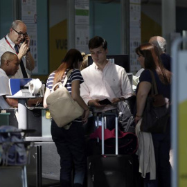Personal de facturación de Vueling atiende a los viajeros en el Aeropuerto de El Prat, después de que la aerolínea haya cancelado esta mañana una decena de vuelos con destino u origen Barcelona y que la mayoría de rutas acumulen retrasos, a