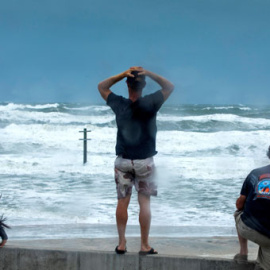 Varias personas observan la llegada del huracán Dorian en la playa de Daytona, en Florida. / EFE