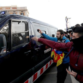Simpatizantes independentistas ante el paso de una furgoneta de los Mossos d'Esquadra, en las inmediaciones de la Llotja de Mar de Barcelona | Alberto Estevez / EFE