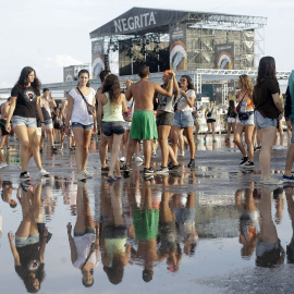 Varias jóvenes tras la tormenta registrada hoy en la primera jornada grande del festival Arenal Sound que se celebra en Burriana. EFE