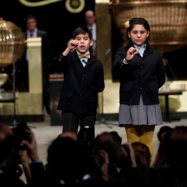 Nerea Pareja Martínez y Alonso Dávalos Durán, primera pareja de niños en el sorteo Extraordinario de la lotería Navidad,  muestran el segundo premio del sorteo. /EFE