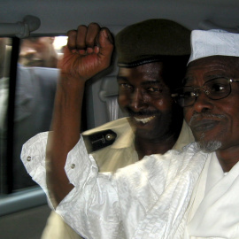 El ex presidente de Chad Hissène Habré (D) levanta su puño cuando sale de un tribunal de Dakar escoltado por un policía senegalés en esta foto de archivo del 25 de noviembre 2005./ REUTERS