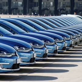 Dos hombres pasean frente a una hilera de Volkswagen e-Golf, durante la conferencia anual de la compañía en Berlín. REUTERS/Tobias Schwarz.