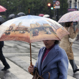 22-11-Una mujer se protege de la lluvia caía en Oviedo, a 20 de noviembre de 2023.