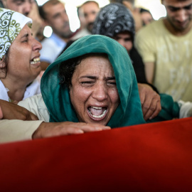 Amigos y familiares de las víctimas del atentado yihadista que causó al menos 30 muetros en Suruc ayer asisten al funeral de 16 de los fallecidos en Gaziantep (Turquía) hoy, 21 de julio de 2015./ AFP. BULENT KILIC