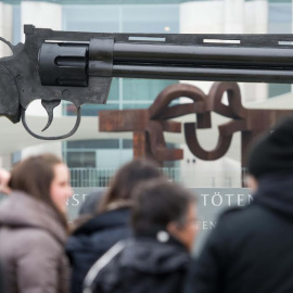 La gente mira un arma de gran tamaño colocada por activistas pacifistas frente a la Cancillería Federal en Berlín. AFP