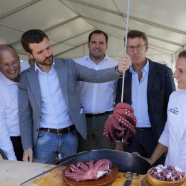 El presidente del Partido Popular, Pablo Casado, sacando un pulpo y el presidente de la Xunta de Galicia, Alberto Núñez Feijóo, acompañados por cargos del partido en la localidad de Cerdedo-Cotobade. /EFE