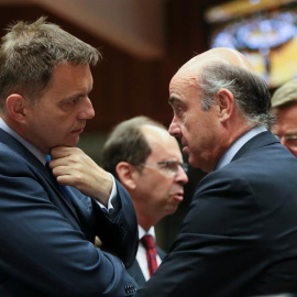 El ministro español de Economía y Competitividad en funciones, Luis de Guindos (d), conversa con el ministro eslovaco de Finanzas, Peter Kazimir, al inicio de la reunión del Ecofin. / OLIVIER HOSLET (EFE)