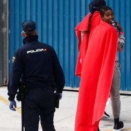 Una joven migrante rescatada en el Mediterráneo muestra su alegría tras desembarcar del Open Arms