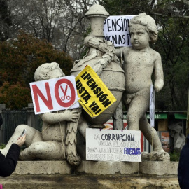 Una estatua del centro de Madrid con las pacartas y carteles de una manifestación de jubilados demandando mejores pensiones. AFP/Javier Soriano