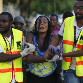 Dos sanitarios ayudan a una mujer que ha escapado de la Universidad de Garissa, en el este de Kenia, donde al menos 147 personas han muerto en un ataque con rehenes reivindicado por el grupo islamista Al Shabab.- Dai Kurokawa (EFE)