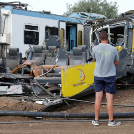 Un hombre mira los restos en el lugar donde dos trenes de pasajeros chocaron en medio de un olivar en la localidad meridional de Corato , cerca de Bari , Italia.- REUTERS