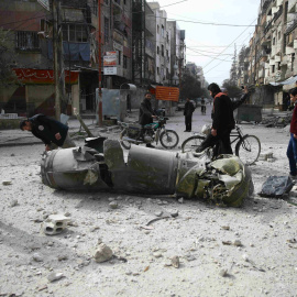 Unos niños, observando un misil tras los bombardeos en  la ciudad de Duoma en la zona de Guta Oriental, cera de Damasco.