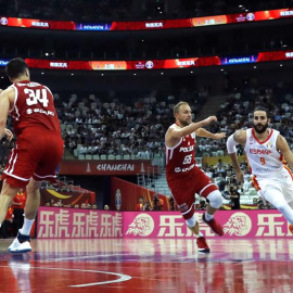 El base de la selección española Ricky Rubio (d) conduce un balón con base polaco ALukasz Koszarek. /EFE