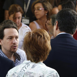 El líder de Podemos, Pablo Iglesias (i), se dirige al secretario general socialista, Pedro Sánchez (d), tras guardar hoy un minuto de silencio en memoria de las víctimas del atentado perpetrado anoche Niza, en el Congreso de los Diputados.-