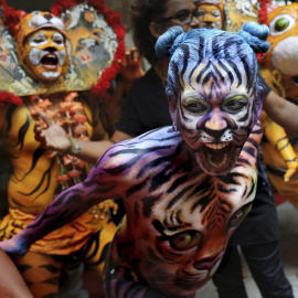 Bailarines indios, pintados y disfrazados de tigres, actúan durante el Día Internacional del Tigre en Calcuta, India, hoy 29 de julio de 2015. Varios estudiantes de Calcuta tratan de sensibilizar a la población sobre la difícil situación de