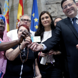 El president de la Generalitat, Ximo Puig (d) y la consellera de Sanidad, Carmen Montón, muestran una de las tarjetas sanitarias tras la presentación del Plan de Universalización de la Sanidad en la Comunitat Valenciana. -EFE/ Juan Caros Cá