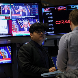 Trabajadores en la Bolsa de Nueva York mientras las pantallas muestran la rueda de prensa  del presidente de la Junta de la Reserva Federal, Jerome Powell.