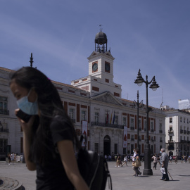 Una mujer con mascarilla en la Puerta del Sol, durante el último día en el que es obligatorio el uso de la mascarilla en exteriores.