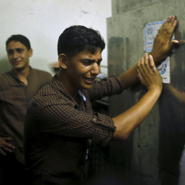 Un amigo del joven asesinado por Israel llora en la morgue hasta donde ha sido trasladado el cuerpo del fallecido. REUTERS