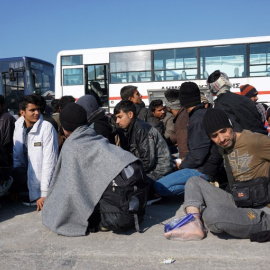 Migrantes y refugiados esperan a ser recogidos en autobuses para entrar en el 'hotspot' de Moria, en Grecia. - AFP