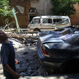 Un niño camina junto a vehículos y edificaciones dañados por un ataque aéreo hoy, jueves 21 de julio de 2016, en Douma (Siria), / EFE
