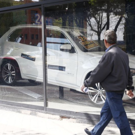 Un peatón pasa por delante de un concesionario de autonóviles. E.P.