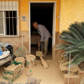 Un hombre elimina el lodo acumulado por las lluvias torrenciales en su casa de Orihuela, Alicante.- JON NAZCA / REUTERS