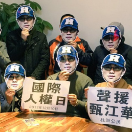 Varias personas posan con una máscara con la cara del activista chino Zhen Jianghua como muestra de apoyo tras su detención en septiembre de 2017.-CHINA CHANGE