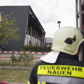 Un bombero alemán junto al edificio incendiado en Neuen, cerca de Berlín, que estaba siendo habilitado para ser un centro para refugiados. REUTERS/Axel Schmidt