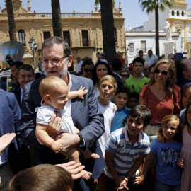 El presidente del Gobierno, Mariano Rajoy, saluda a varios vecinos de La Palma del Condado (Huelva). REUTERS