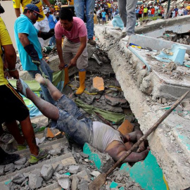 Unas personas rescatan un cuerpo entre los escombros en la localidad de Pedernales (Ecuador). EFE/José Jácome
