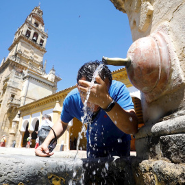 Un joven se refresca en una fuente céntrica de Córdoba debido a las altas temperaturas registradas.