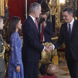 El presidente del Gobierno, Pedro Sánchez, saluda a Felipa VI, a la reina Letizia, y a la princesa Leonor, a su llegada a la recepción oficial después del desfile del Día de la Fiesta Nacional, el Palacio Real en Madrid. EFE/ Juan Carlos Hi