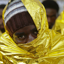 Un hombre espera a desembarcar del barco de la Guardia Costera de Sicilia, en Italia. REUTERS/Antonio Parrinello