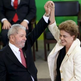 La presidenta de Brasil, Dilma Rousseff, levanta el brazo de su antecesor,  Luiz Inacio Lula da Silva, tras su toma de posesión como ministro de la Presidencia en el Palacio Planalto, en Brasilia. REUTERS/Adriano Machado