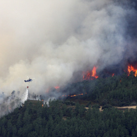 Un helicóptero descarga agua sobre el incendio forestal declarado en la Sierra de Gata, en el límite de Cáceres con la provincia de Salamanca. EFE/Carlos García