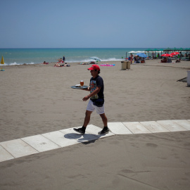 Un camarero sirve una cerveza en un bar en la playa de Torremolinos (Málaga). REUTERS/Jon Nazca