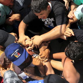 Refugiados sirios se amontonan para entrar en el estadio de la isla griega de Kos. REUTERS / Yannis Behrakis