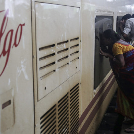 Varias personas observan el interior de uno de los vagones de un tren de la empresa española Talgo a su llegada a la estación central de Bombay. EFE/Divyakant Solanki