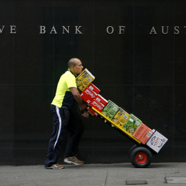 Un trabajador pasa delante del Banco de la Reserva de Australia, en Sydney. REUTERS/Daniel Munoz