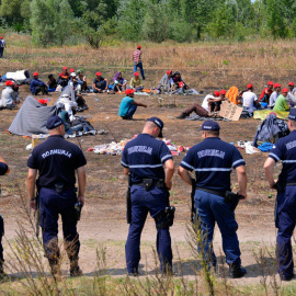 Policías serbios vigilan a un grupo de refugiados que permanecen en huelga de hambre en la frontera serbo-húngara cerca de Horgos. EFE